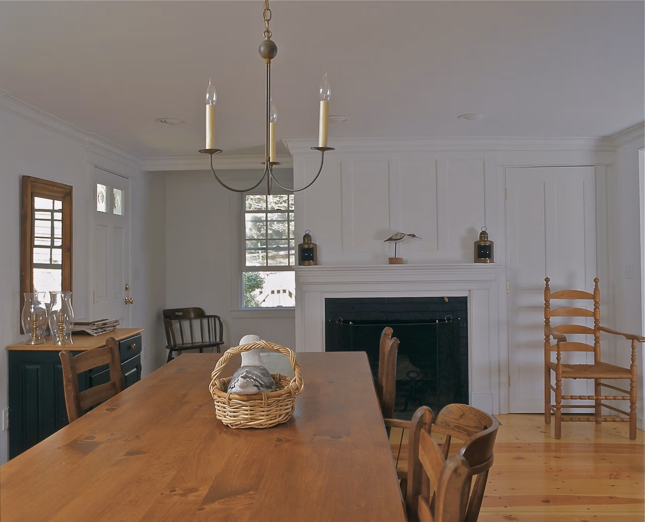 Paneled fireplace and mantel at dining room, open plan interior, traditional Cape Cod house, Chatham MA