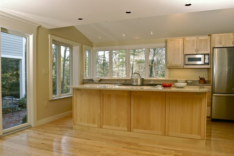 View of renovated kitchen with maple island, vaulted ceiling, boxout bay window and ribbon windows above counter. Hingham MA