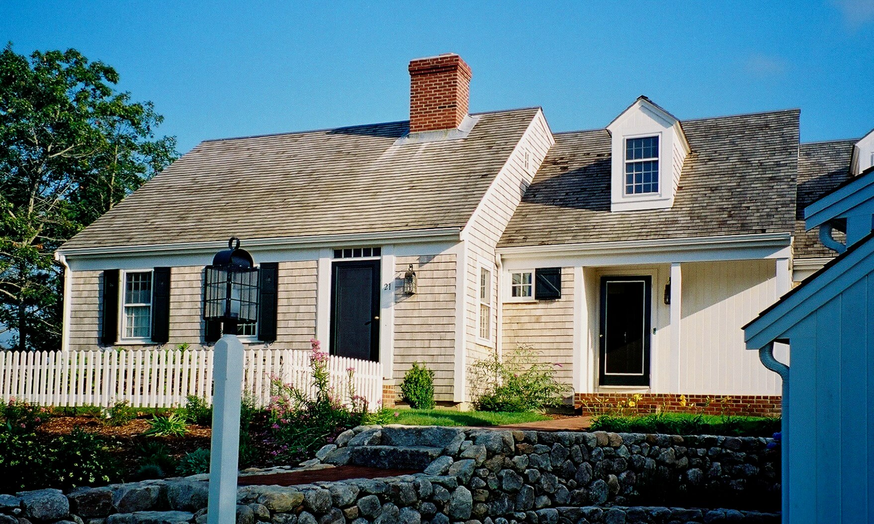 Classic "half Cape" with doghouse dormer and farmer's porch entry. Cape Cod House in Orleans MA.